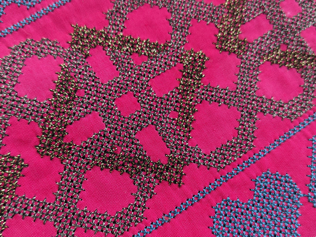 Detail of metallic embroidery on pink handmade purse